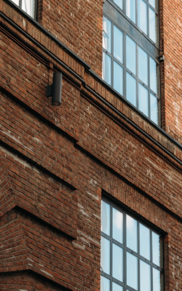 Close-up of a brick building with large windows and industrial-style details.