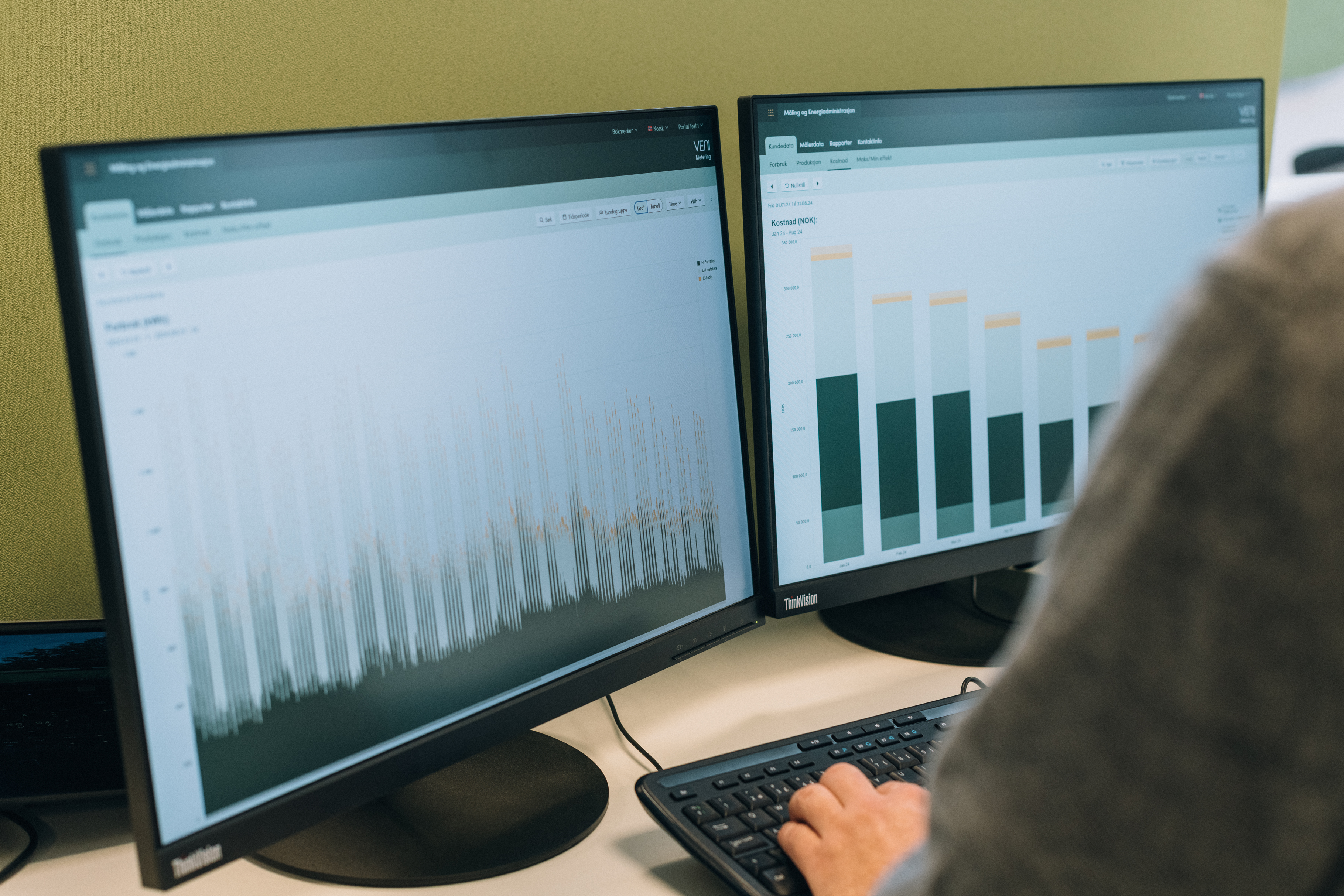 Close-up of two monitors showing data visualizations from the VENI Customer Portal.
