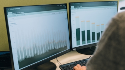 Närbild av två skärmar som visar datavisualiseringar från VENI-kundportalen.
